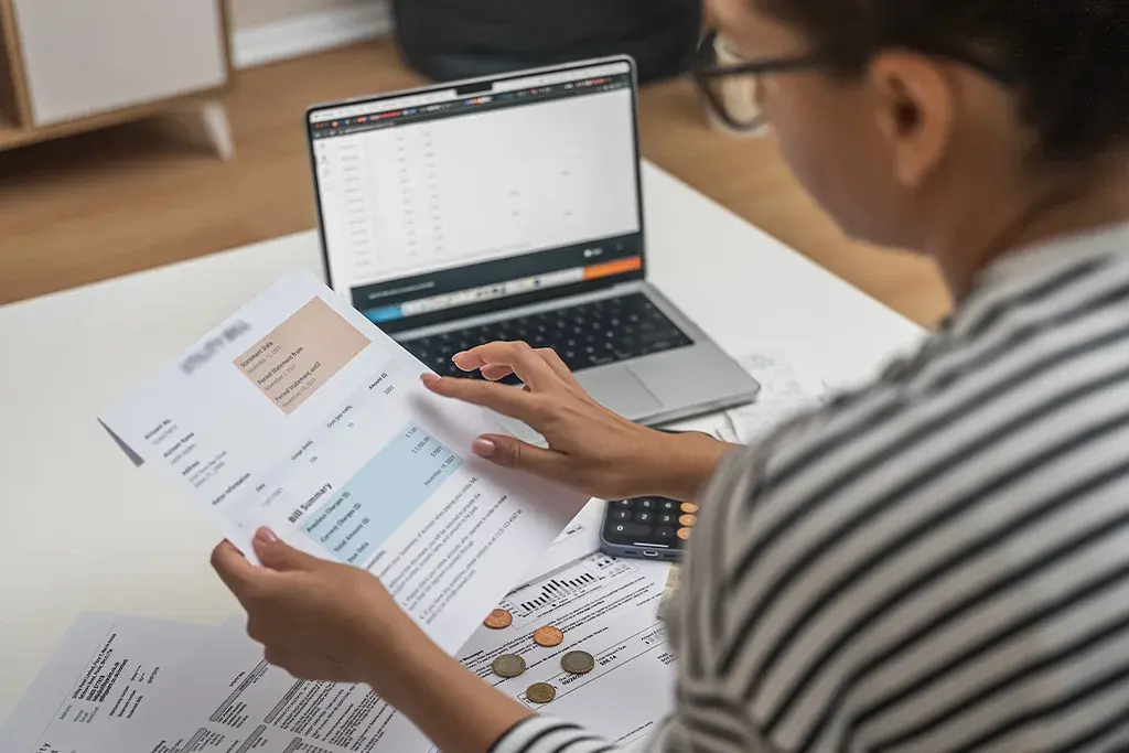 Client paperwork being checked against the books on a laptop